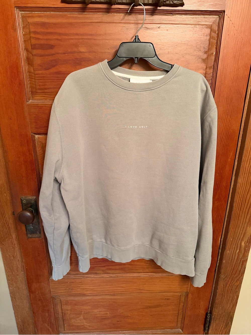 Love Ugly" sweatshirt features a minimalist chest logo